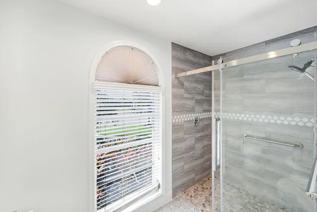 a bathroom with a glass door shower and a sink