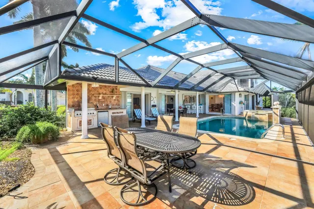 a view of a patio with table and chairs potted plants with floor to ceiling window and potted plants