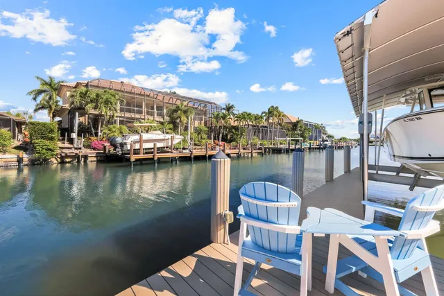 a view of a lake with couches chairs and a table of the ocean