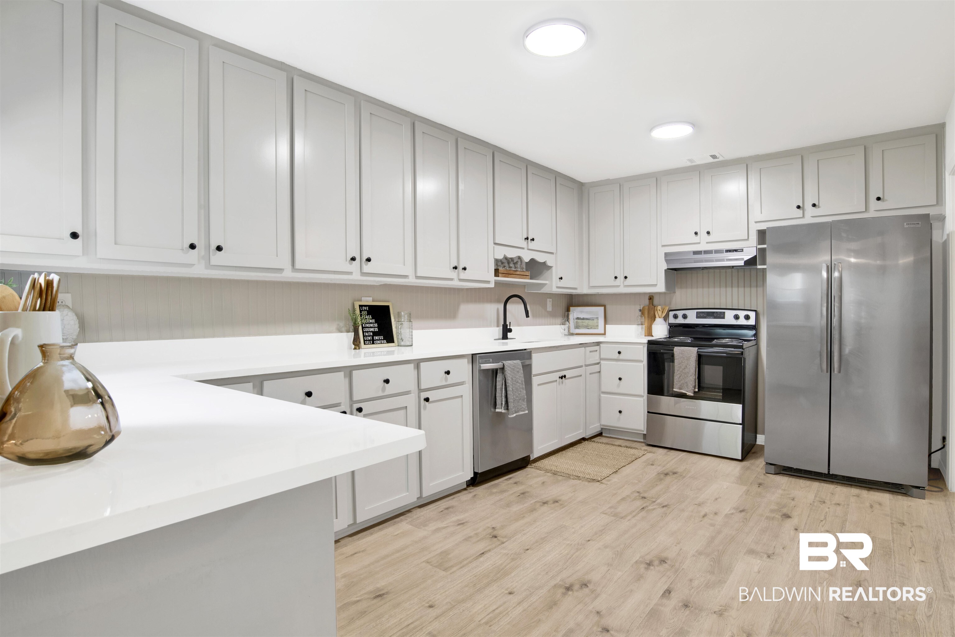 317 Lee Street Chickasaw, AL 36611 - Photo 9 of 40 Kitchen featuring appliances with stainless steel finishes, light countertops, light wood-style floors, gray cabinetry, and under cabinet range hood