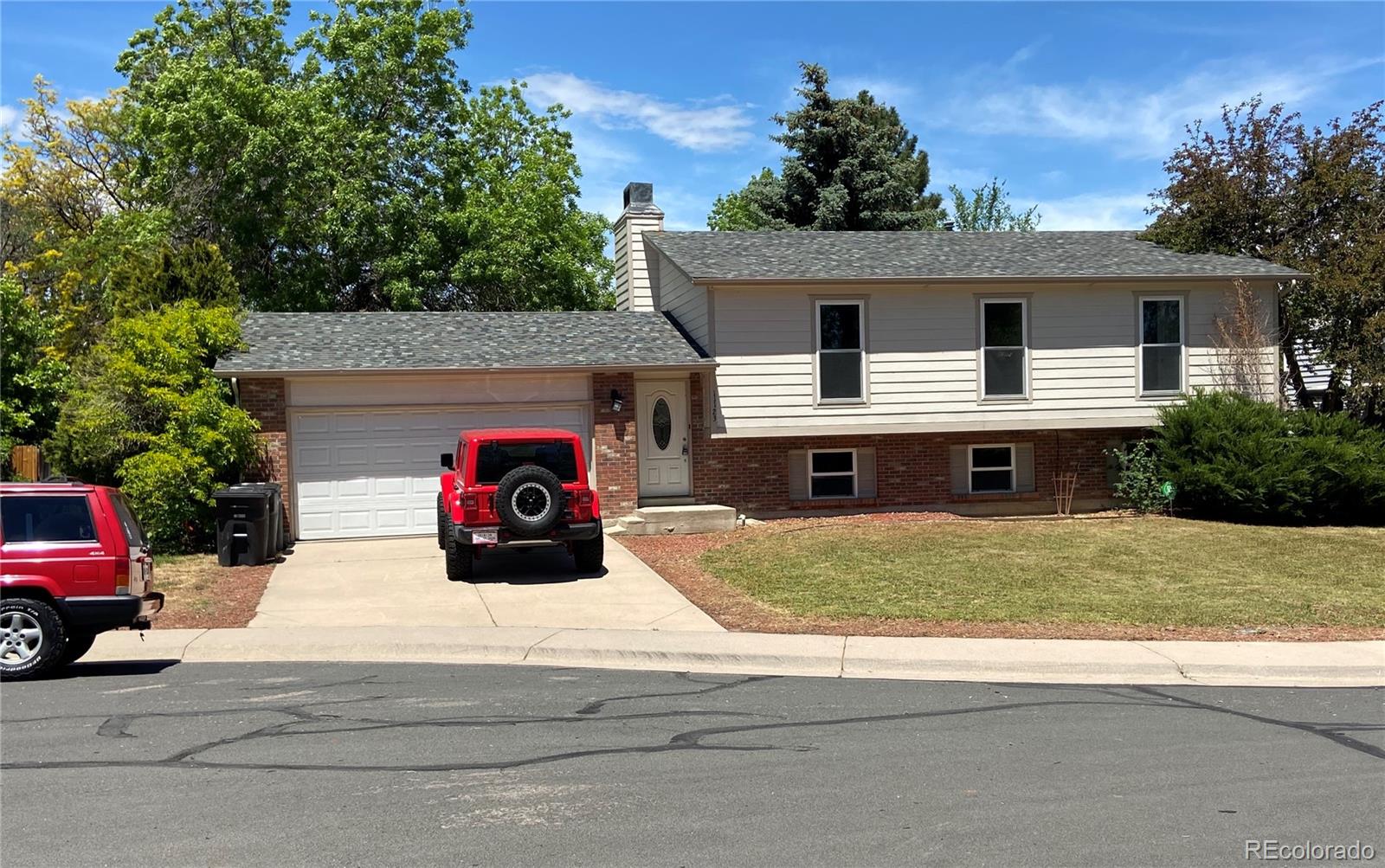 a view of a house with a patio and a yard