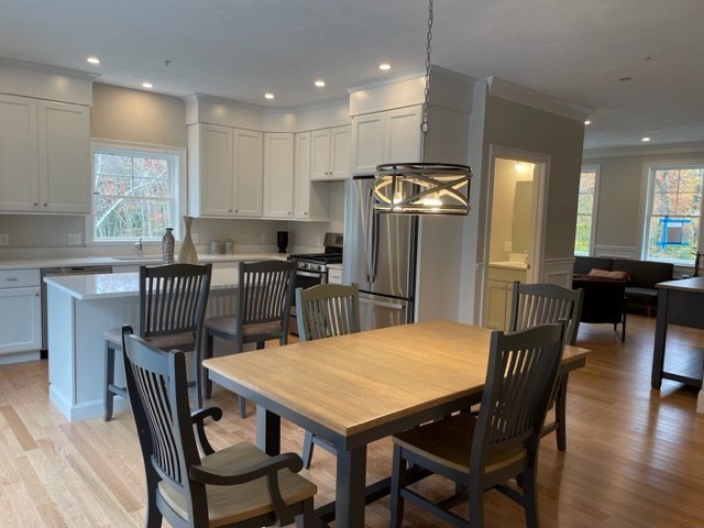 1 Shoemaker Lane, Unit 1 Upton, MA 01568 - Photo 2 of 6 a kitchen with stainless steel appliances granite countertop a dining table chairs refrigerator and a sink