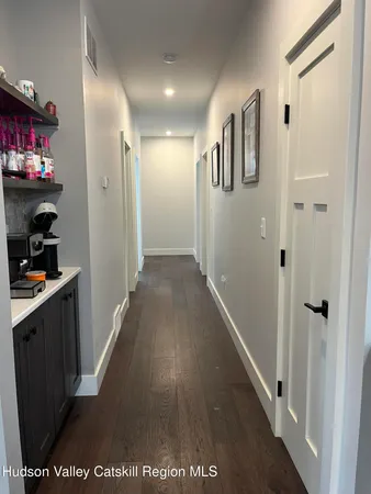a view of hallway with stairs and wooden floor