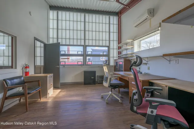 a view of a workspace with furniture and a window