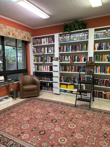 a living room with furniture and a book shelf