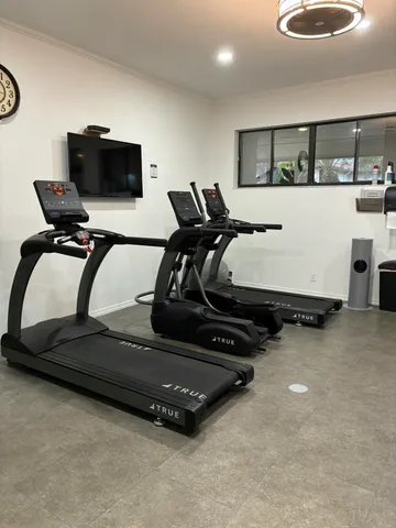 a room with gym equipment and a flat screen tv