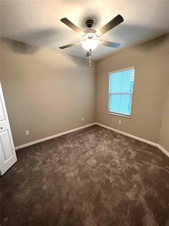 31657 Blue Passing Loop Wesley Chapel, FL 33545 - Photo 4 of 5 an empty room with a ceiling fan and window