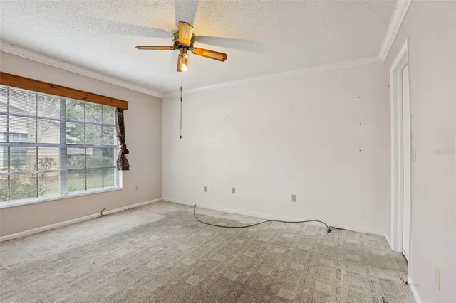 an empty room with a ceiling fan and window