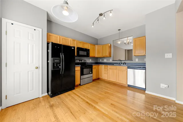 a kitchen with stainless steel appliances kitchen island granite countertop a refrigerator and a sink
