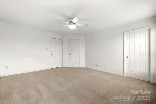a view of an empty room with a ceiling fan