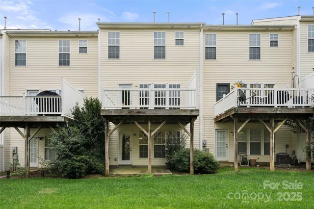 a view of a yard with large trees and a wooden deck
