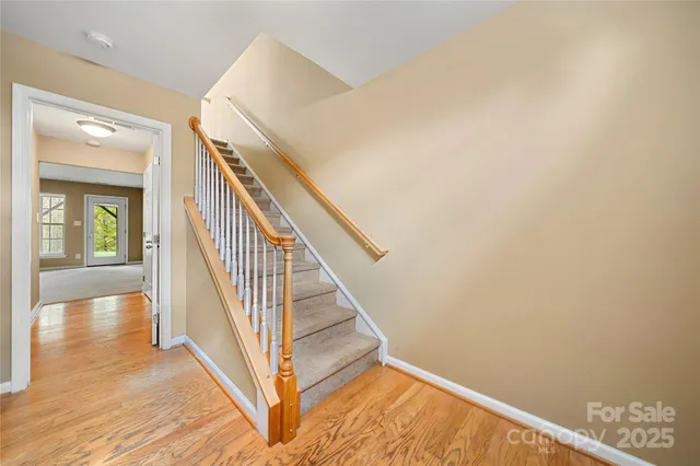 a view of a hallway with wooden floor and staircase