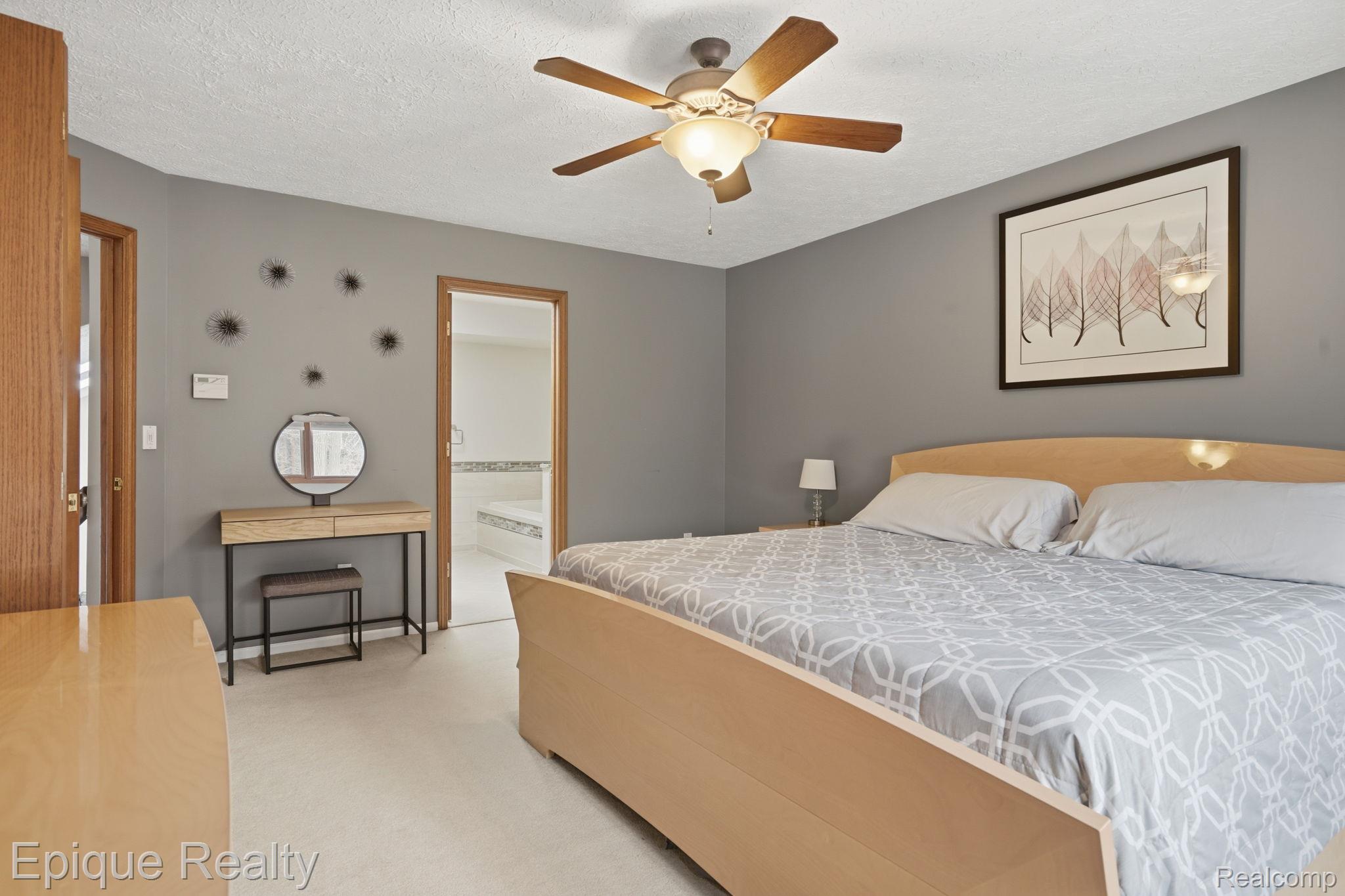 6607 Ridgeview Drive Clarkston, MI 48346 - Photo 21 of 25 Bedroom with light colored carpet, ensuite bathroom, ceiling fan, and a textured ceiling