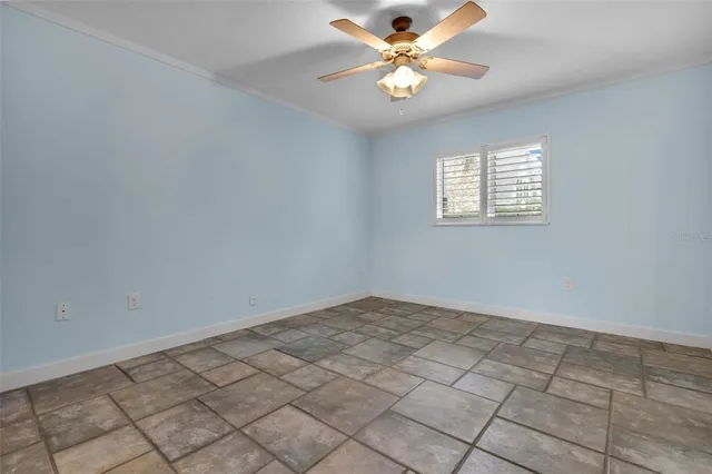 an empty room with closet and a chandelier fan