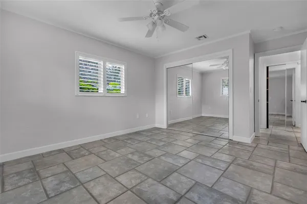 an empty room with windows and fan
