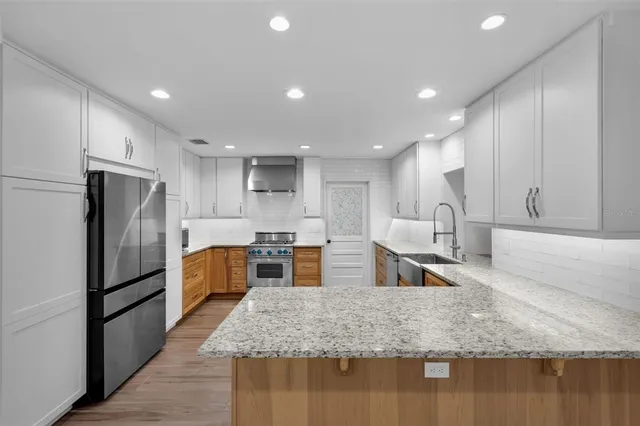 a kitchen with stainless steel appliances granite countertop a stove and a sink