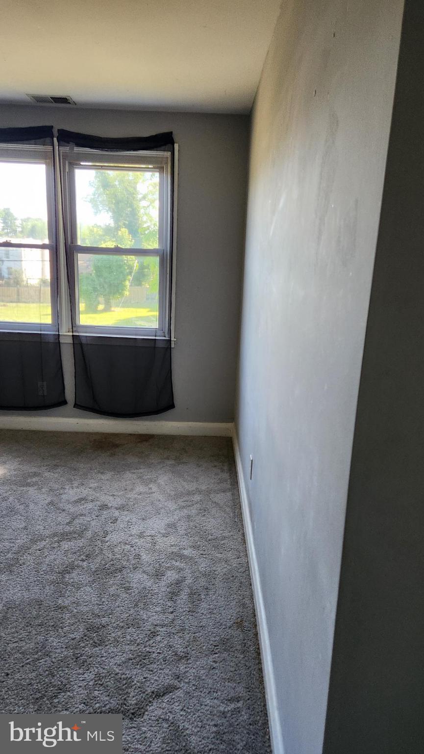 1024 Wicklow Road Baltimore, MD 21229 - Photo 21 of 44 an empty room with wooden floor and windows