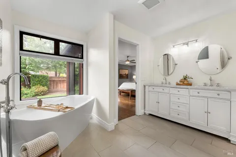 a bathroom with a tub sink and mirror
