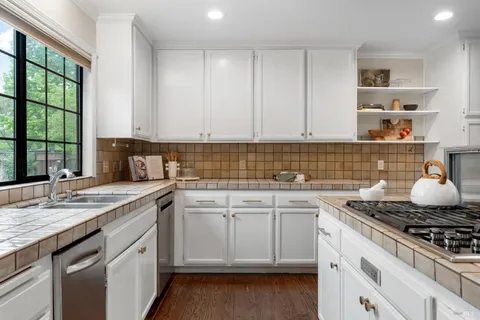 a kitchen with granite countertop a sink stove and cabinets