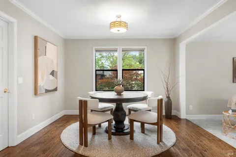 a dining room with wooden floor and a window