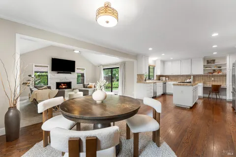 a living room with stainless steel appliances a dining table and a couch