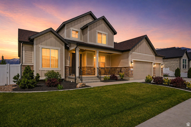 1434 West Stable Street Lindon, UT 84042 - Photo 1 of 76 AI enhanced twilight. Craftsman house featuring board and batten siding, covered porch, a garage, and stone siding