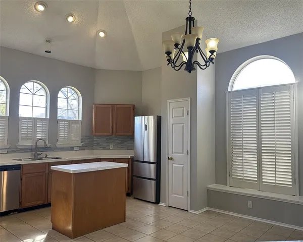a view of a kitchen with a sink and refrigerator