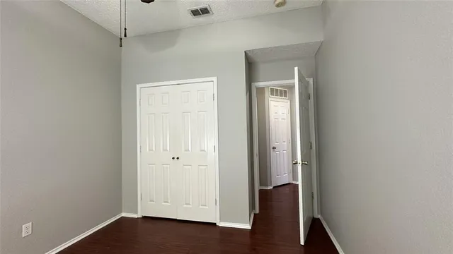 an empty room with wooden floor and closet