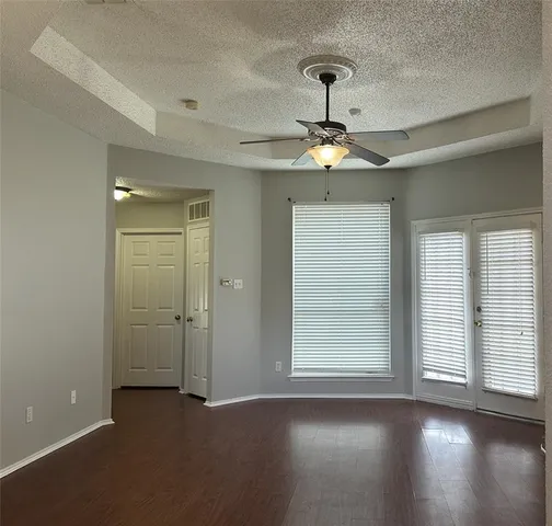 a view of empty room with wooden floor and ceiling fan