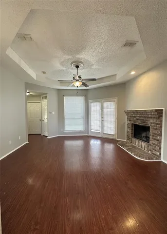 a view of empty room with wooden floor and fireplace