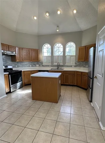 a kitchen with stainless steel appliances granite countertop a stove sink and cabinets