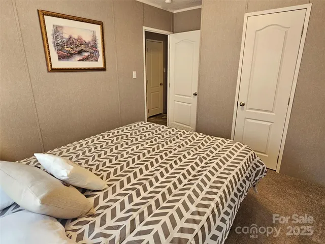 a bedroom with a bed and a painting on the wall