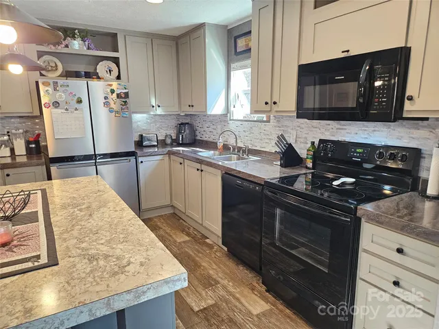a kitchen with stainless steel appliances granite countertop a sink stove and microwave