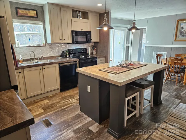 a kitchen with stainless steel appliances granite countertop a stove refrigerator sink and microwave