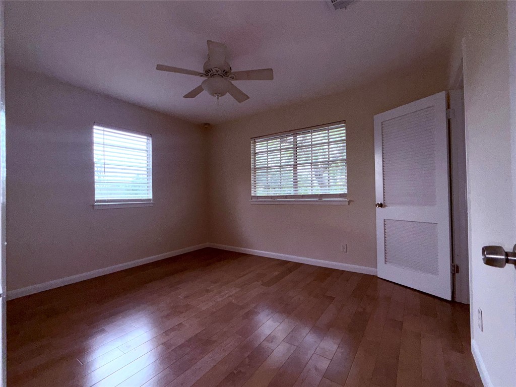 5413 Coventry Lane Austin, TX 78723 - Photo 19 of 25 a view of an empty room with wooden floor and a window
