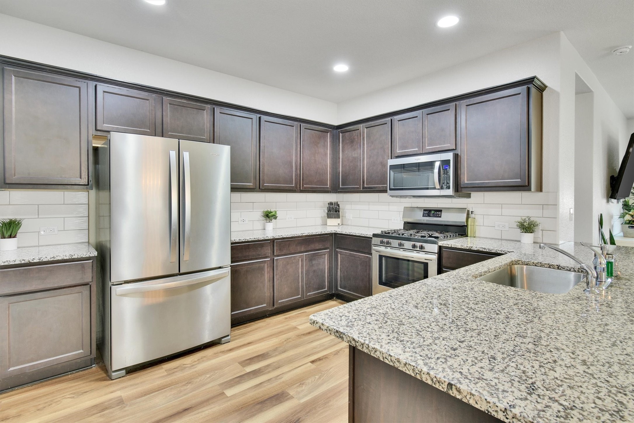 324 Shiner Lane Georgetown, TX 78626 - Photo 11 of 39 a kitchen with granite countertop wooden cabinets a refrigerator and a stove top oven