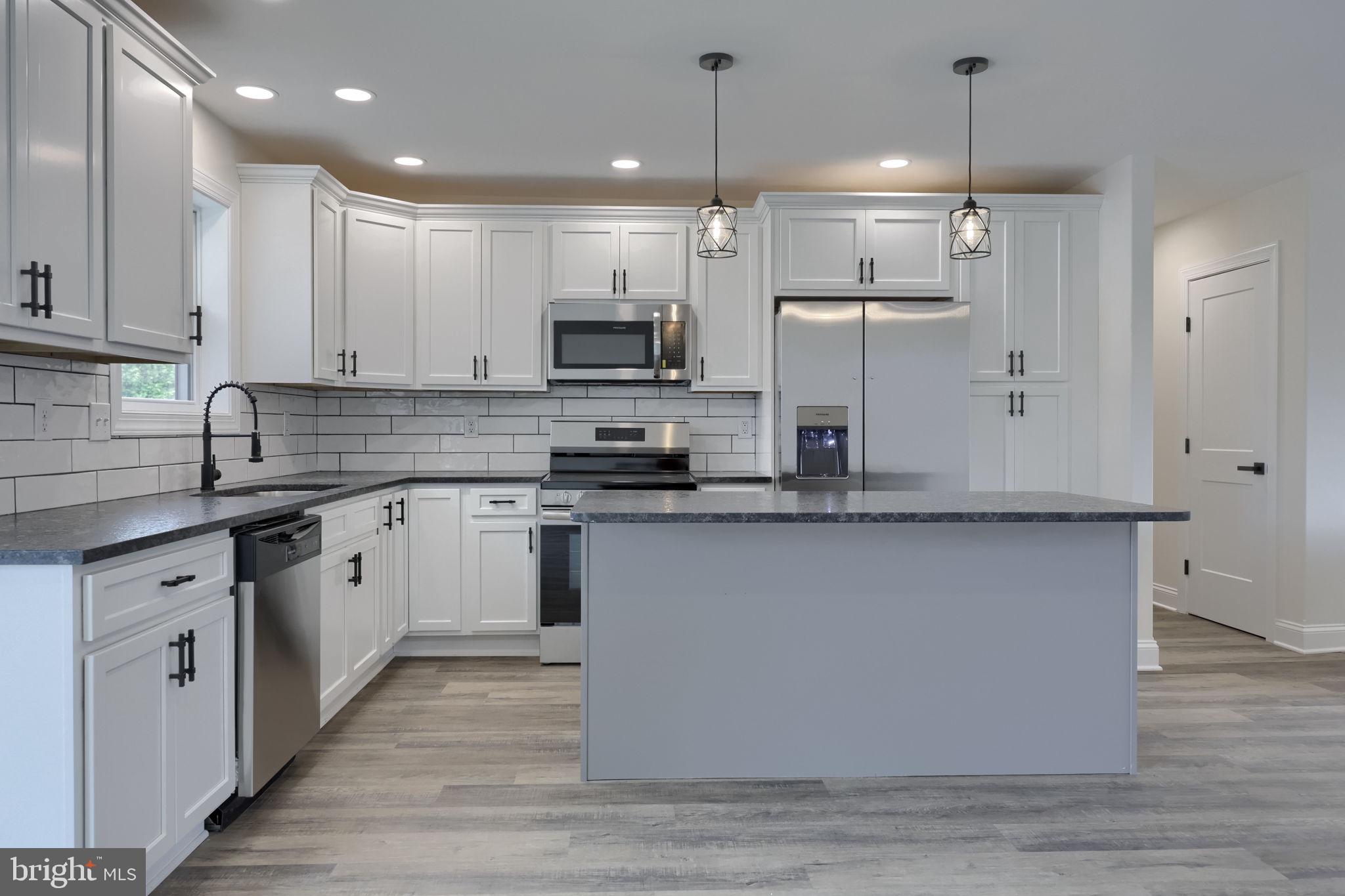 310 Kendale Road Red Lion, PA 17356 - Photo 13 of 42 a large kitchen with stainless steel appliances granite countertop a stove a sink and a refrigerator