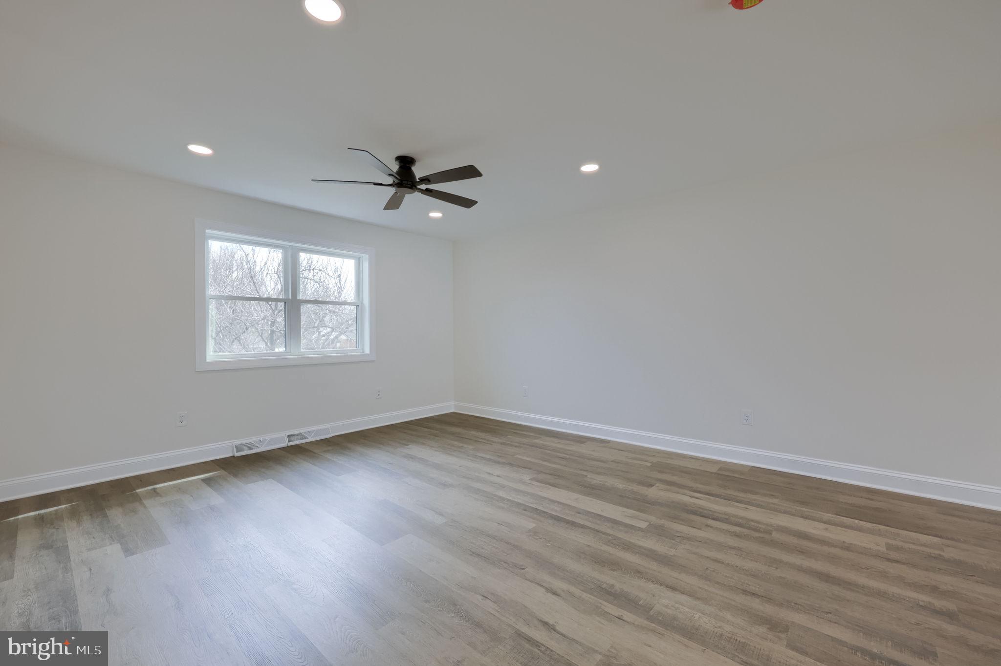 310 Kendale Road Red Lion, PA 17356 - Photo 4 of 42 an empty room with wooden floor ceiling fan and windows