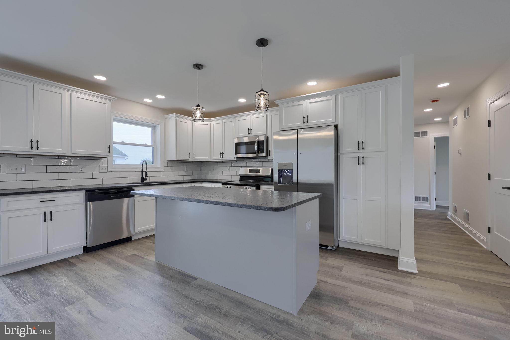 310 Kendale Road Red Lion, PA 17356 - Photo 10 of 42 a kitchen with stainless steel appliances granite countertop a refrigerator a sink dishwasher a stove and white cabinets with wooden floor
