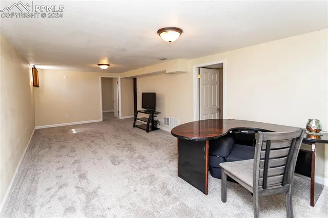 a living room with furniture a desk and chair