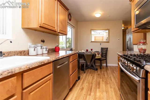 a kitchen with stainless steel appliances granite countertop sink stove top oven and cabinets
