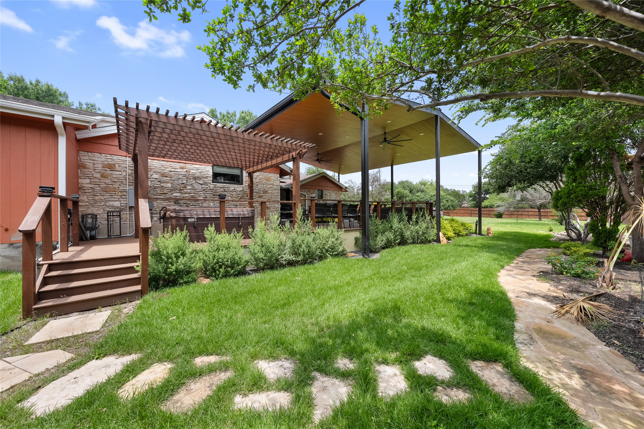 301 Oak Ridge Road Georgetown, TX 78628 - Photo 28 of 38 Backyard featuring a stone paver pathway, manicured lawn, and mature trees
