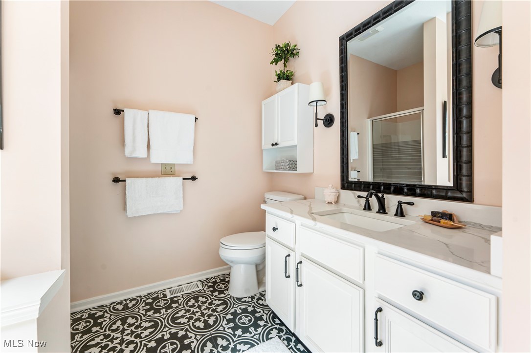 2444 Charing Cross Road Northwest Canton, OH 44708 - Photo 19 of 40 Bathroom featuring vanity, toilet, an enclosed shower, and tile patterned flooring