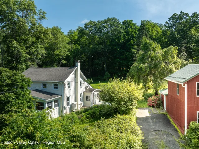 a view of a house with a yard and potted plants