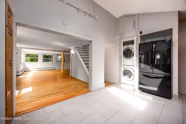 a view of a hallway with wooden floor and living room