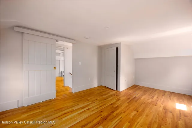 a view of empty room with wooden floor
