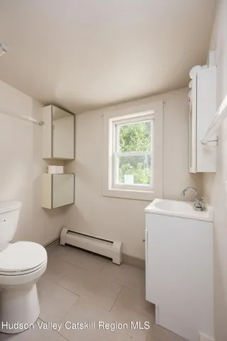 a bathroom with a sink a toilet and window