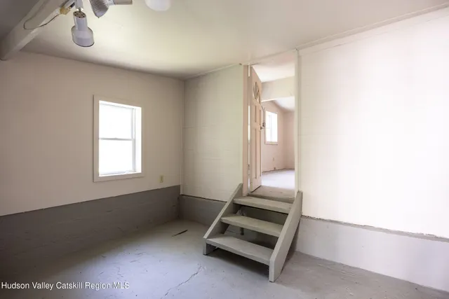 a view of a livingroom with an empty space and a window