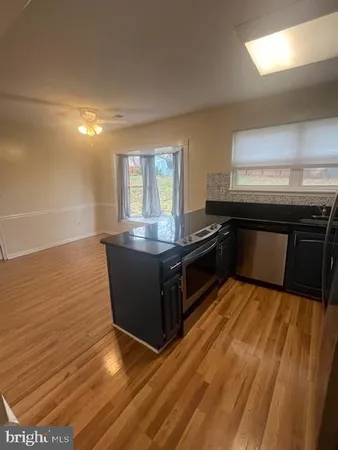 a kitchen with kitchen island granite countertop a stove and a sink