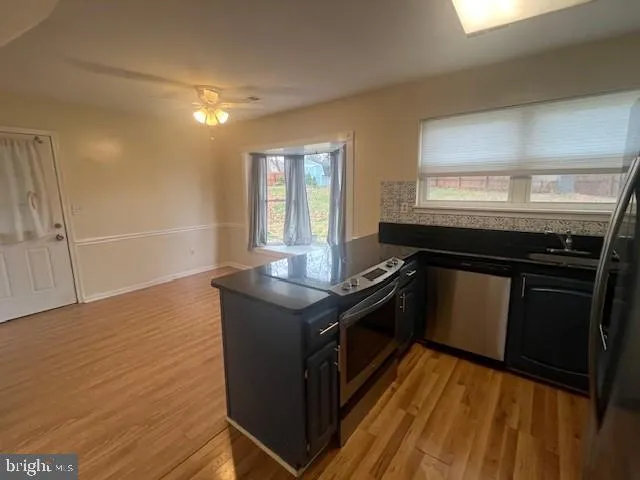 a kitchen with granite countertop a stove and a wooden floors